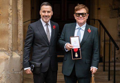 Sir Elton John with his husband David Furnish (left) after being made a member of the Order of the Companions of Honour.(Credit: PA)
