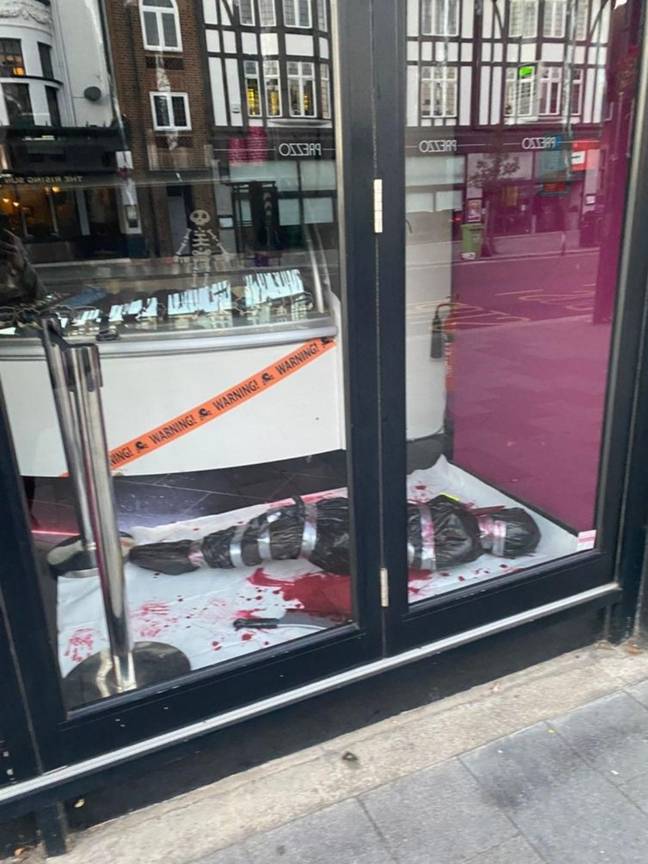 The display features crime scene tape and a fake dead body wrapped up in a bin bag and tape. Credit: @Teddylegs61/ Twitter
