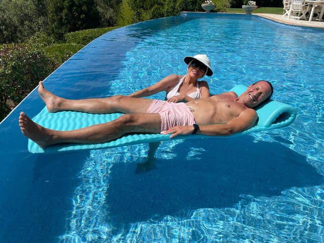 Joan Collins in the pool with her husband Percy Gibson. Credit: Instagram/@joancollinsdbe