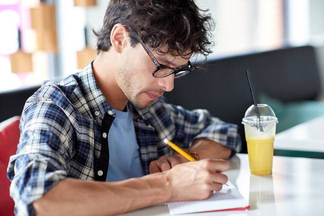 A man writing in a ntoebook. Credit: Alamy / Lev Dolgachov