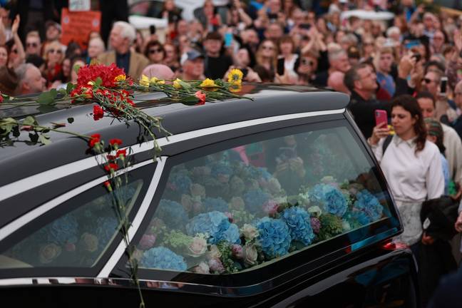 Blue flowers could be seen covering O’Connor’s coffin, while mourners also threw red and yellow flowers on to the roof of the hearse. Credit: Niall Carson/PA Wire