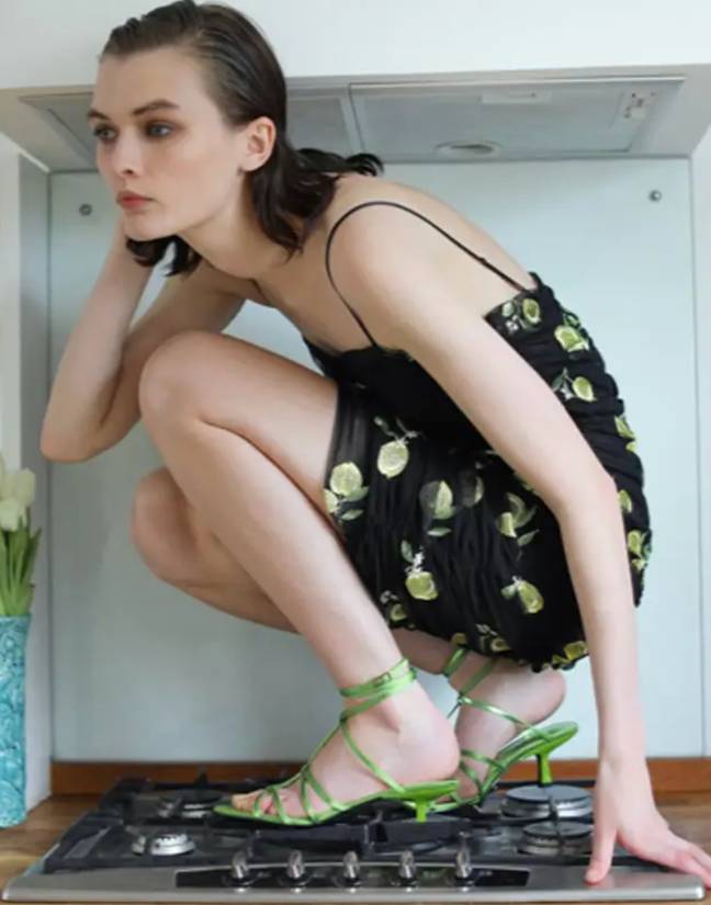 One shot saw a model in strappy green kitten heels inexplicably crouching on a stove top. Credit: Zara