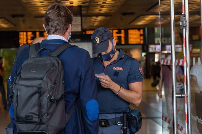 A man having his ID checked by Italian authorities. Credit: Christian Santi / Alamy Stock Photo