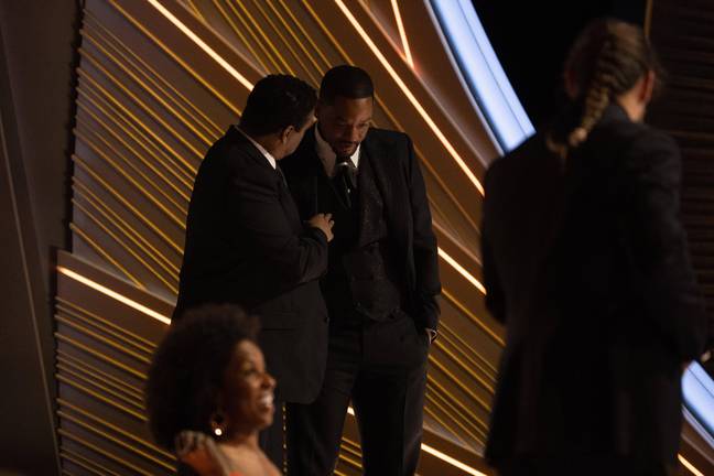 Will Smith talking to Denzel Washington at the Oscars. Credit: Zuma Press / Alamy Stock Photo