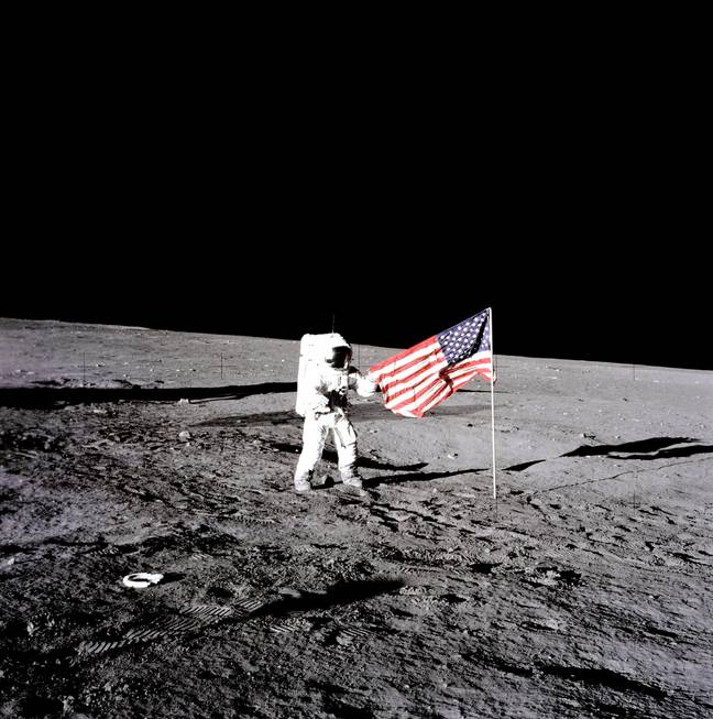NASA Apollo 12 lunar landing mission astronaut Pete Conrad unfurls the American flag on the lunar surface during his first spacewalk November 19, 1969 on the Moon. Credit: NASA/Alamy