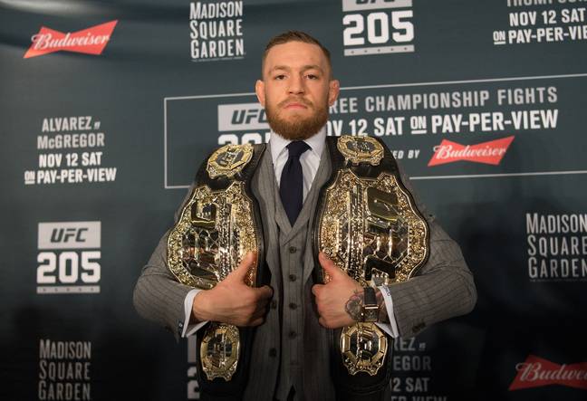 Conor McGregor poses with the UFC featherweight and UFC lightweight titles at UFC 205. Image: Getty 