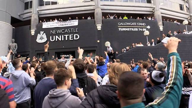Fans outside St James' Park celebrate their new owners. (Credit: PA Images)