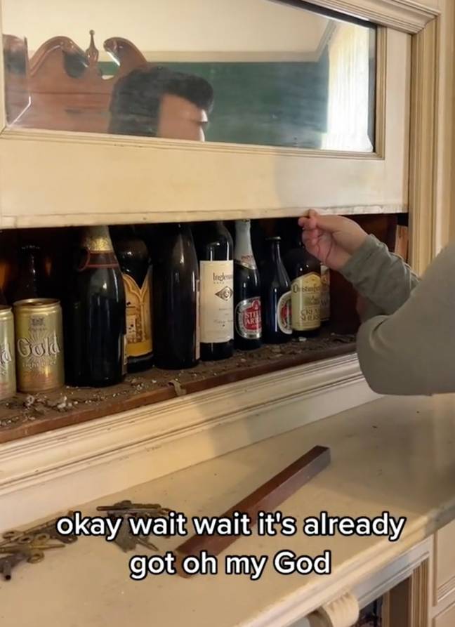 They found a hidden cabinet stuffed with vintage booze. Credit: TikTok/@living_in_history