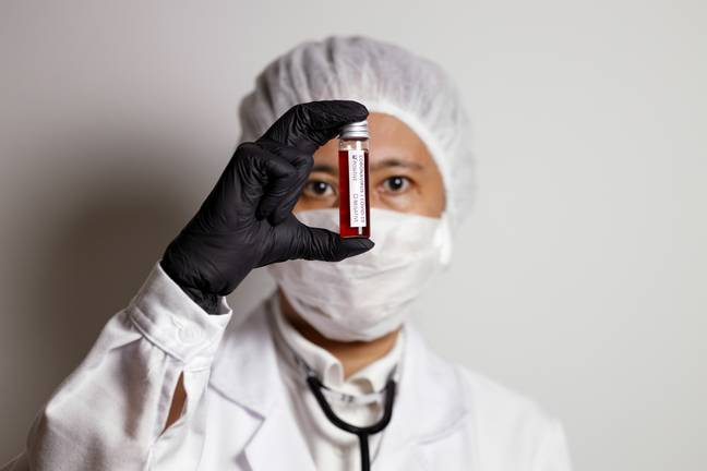 Virologist looks at corona blood sample. Credit: PA