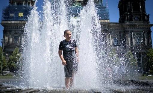 A boy refreshes in a fountain in Berlin, Germany, Sunday, June 30, 2019. Credit: PA