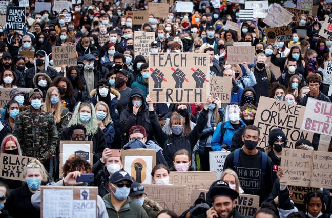 Demonstrators marching through Piccadilly Gardens in Manchester. Credit: PA