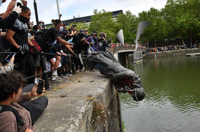 Protesters throw statue of Edward Colston into the Bristol harbour. Credit: PA