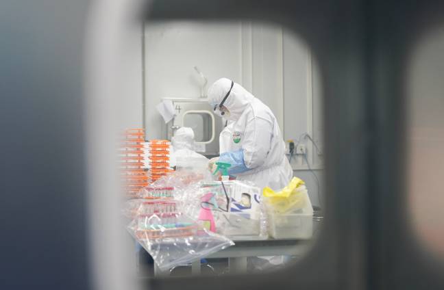 A staff member handles nucleic acid testing samples at a novel coronavirus detection lab in Wuhan, central China's Hubei Province. Credit: PA