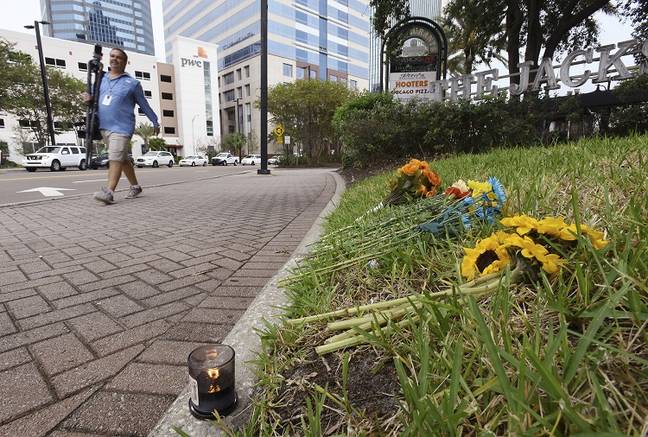Candle and flowers left on the grass outside the site of the Jacksonville shooting. Credit: PA