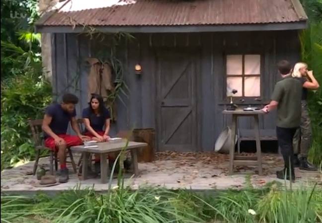 Holly moved to the bushes to avoid watching Malique throw up. (Credit: ITV/I'm A Celebrity)