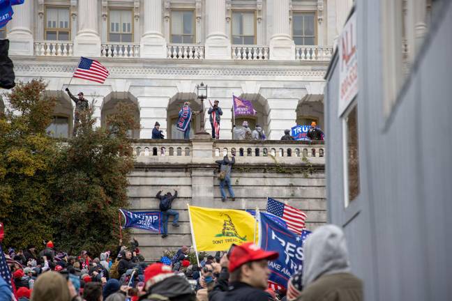 Rioters climbing calls of Capitol (Alamy)