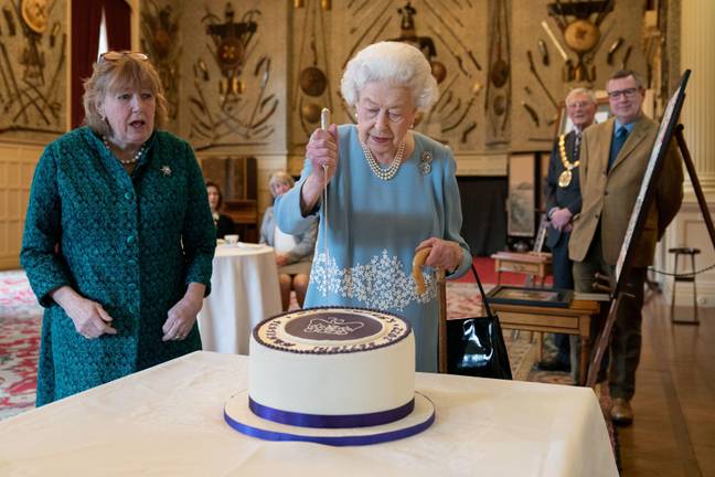 The Queen cut into the cake before declaring it could be finished by someone else (Credit: Alamy)