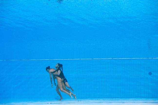 The coach jumped into the pool and swam downwards to reach the unconscious swimmer. Credit: Getty Images