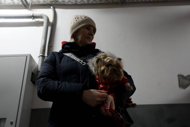 A woman holds a dog in the basement of a residential tower block (Alamy)