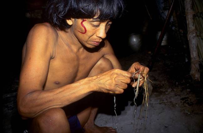Man of the Yanomami tribe sewing. Credit: Alamy