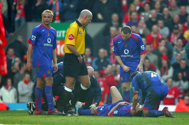 Smith, being held by Gary Neville, immediately after the leg break. (Image Credit: Alamy)