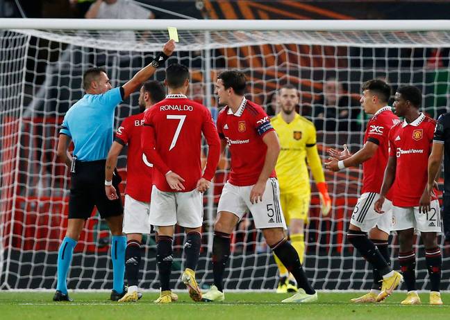Manchester United players argue with the official following the decision to give a penalty after a Lisandro Martinez block. (Alamy)