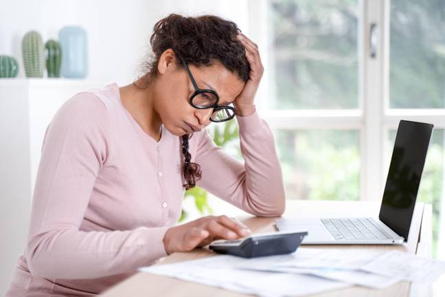 Woman stressed looking at her sad debt, credit: Alamy