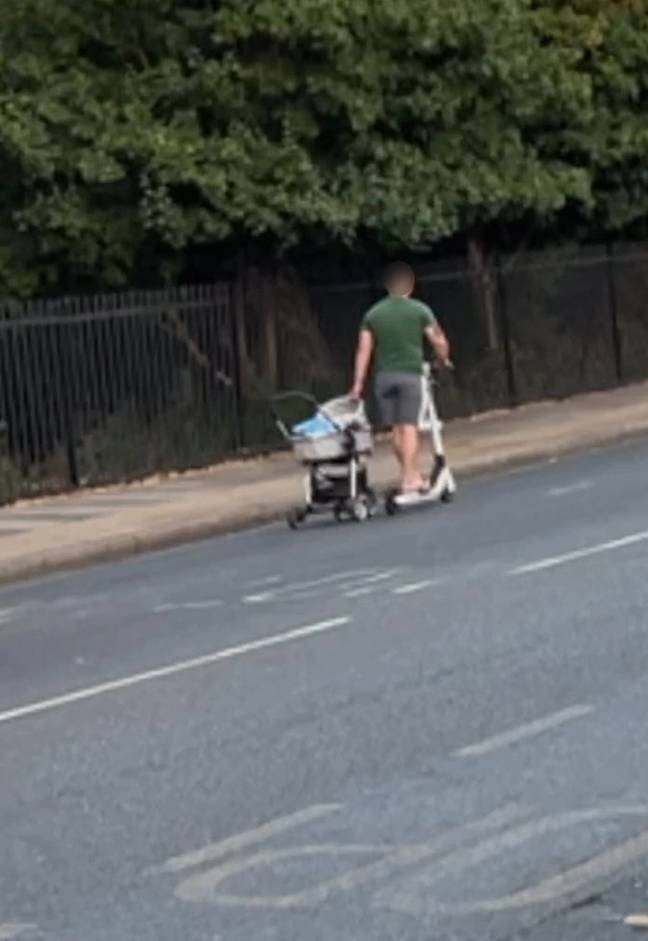 The man was spotted wheeling a pram along the road while he was riding an e-scooter. Credit: Kennedy News &amp; Media