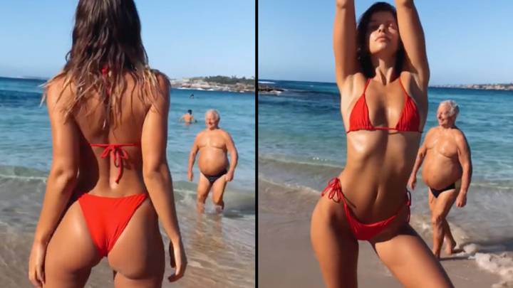 Model striking poses on the beach gets hilariously photobombed by unsuspecting bloke