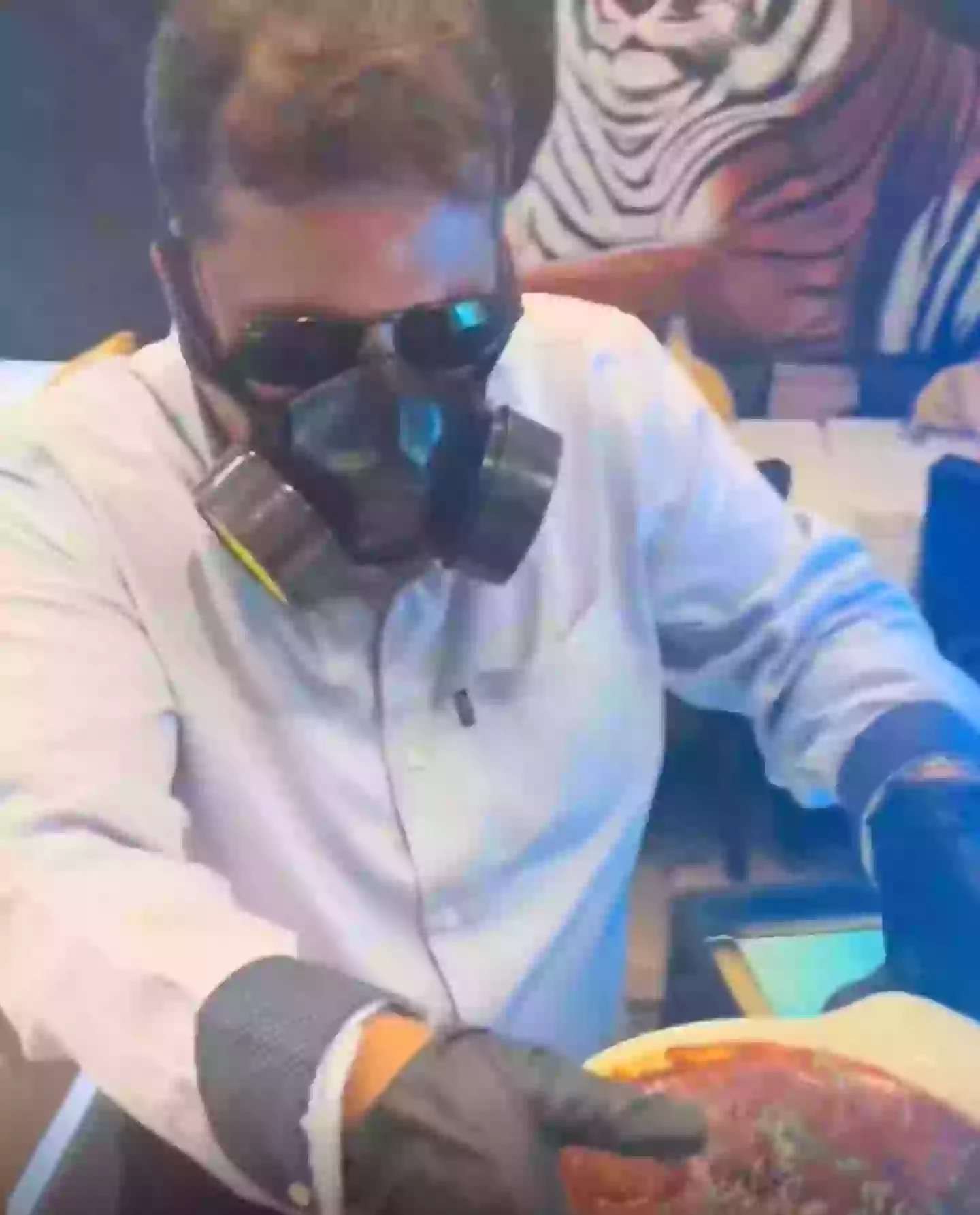 Mr Raj could be seen wearing a gas mask to carry the curry (Twitter)