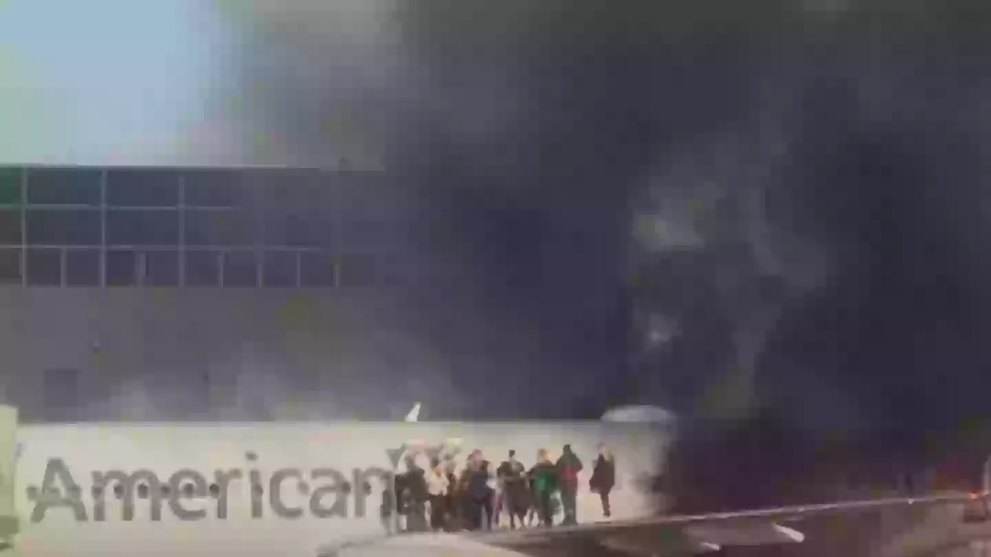 American Airlines plane bursts into flames forcing passengers onto aircraft wing