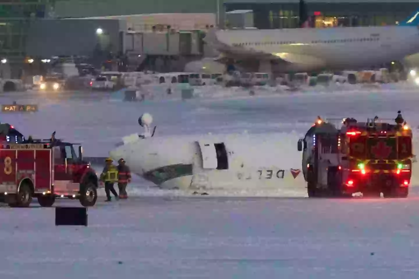 A Delta airlines plane sits on its roof after crashing upon landing at Toronto Pearson Airport in Toronto, Ontario, on Monday (GEOFF ROBINS/AFP via Getty Images)