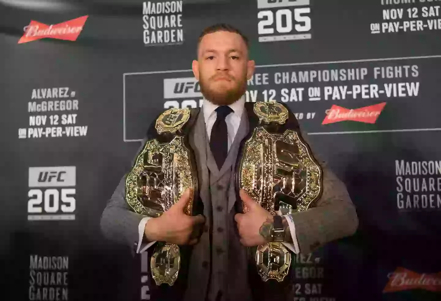 Conor McGregor poses with the UFC featherweight and UFC lightweight titles at UFC 205. Image: Getty