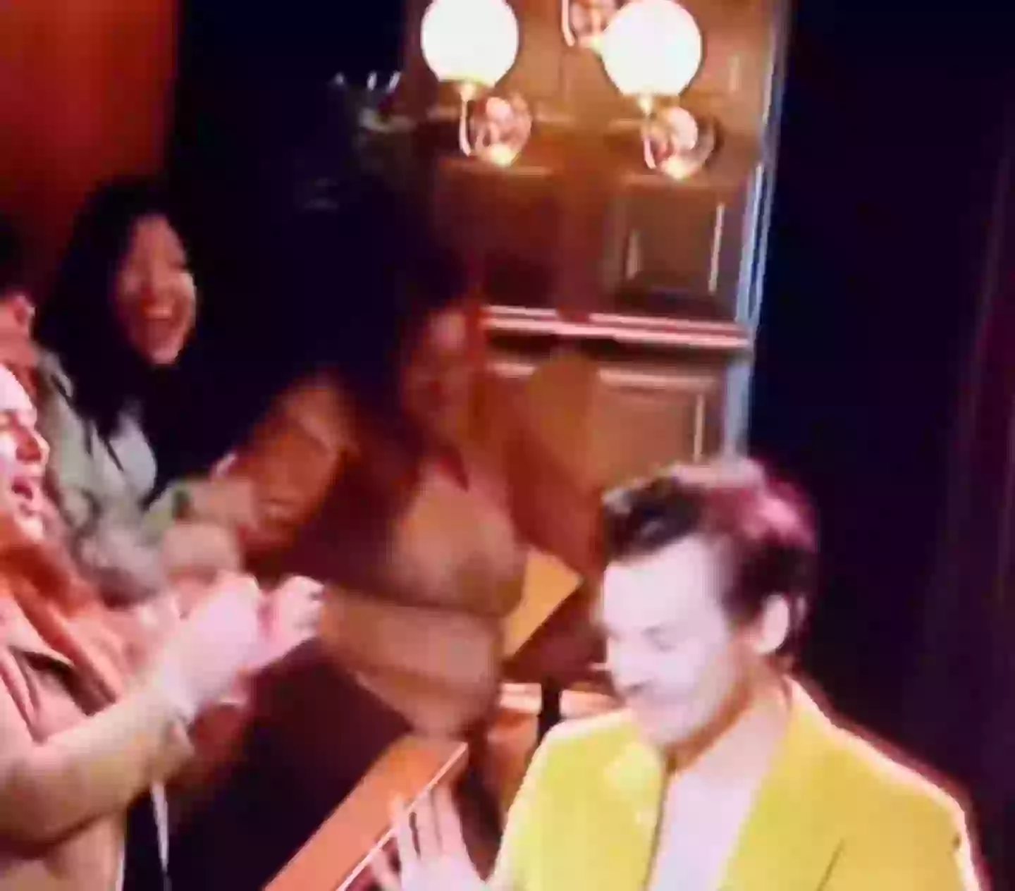 A woman appeared to faint after being fist bumped by Harry Styles.