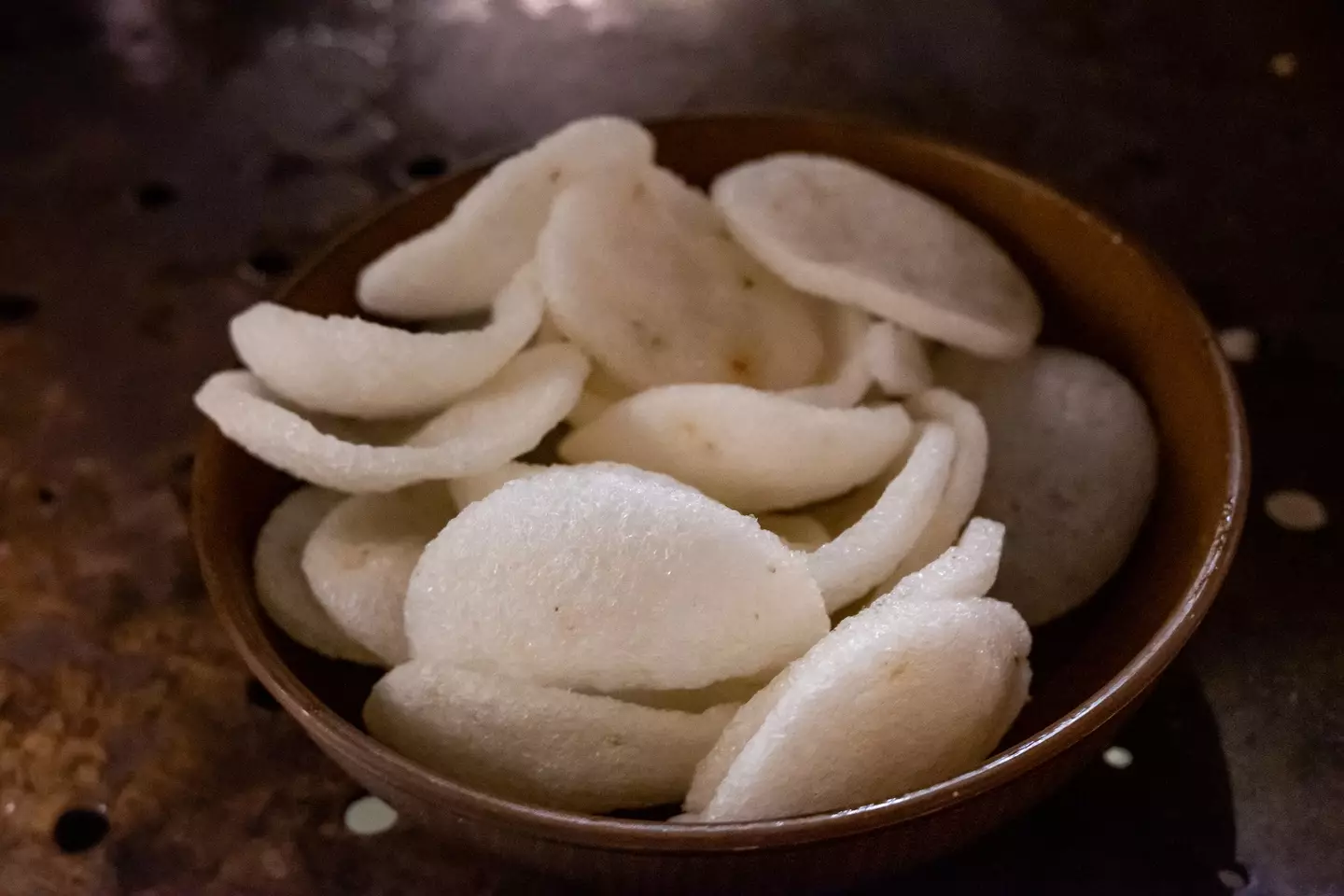 A close-up view of prawn crackers neatly arranged in a bowl (Sunphol Sorakul / Getty Images)