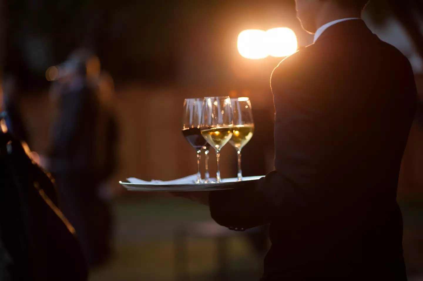 A waiter bringing glasses around a party (Photo by Dylan Goldby at WelkinLight Photography/Getty Images)