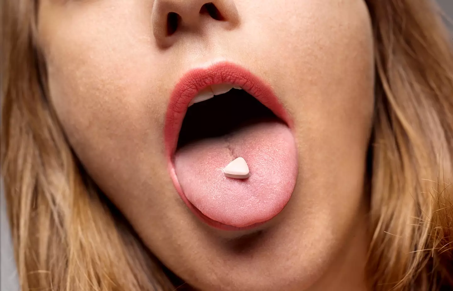 A woman with a pill on her tongue - Peter Dazeley via Getty Images