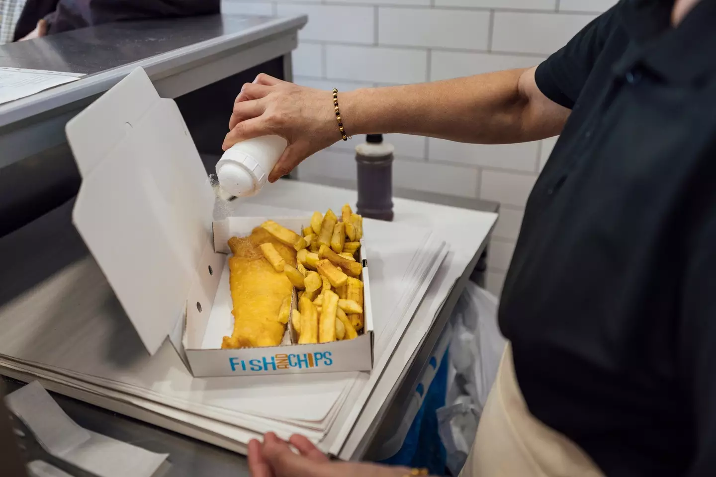 Seasoning some fish and chips - SolStock via Getty Images