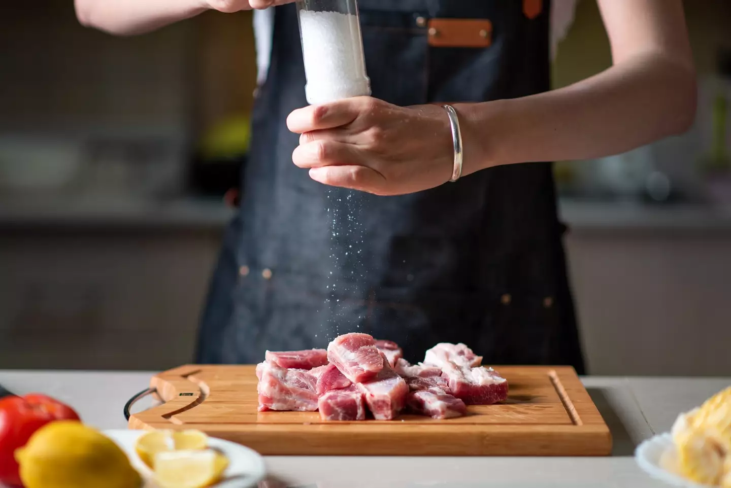 Seasoning some sliced meat - Stefan Tomic via Getty Images