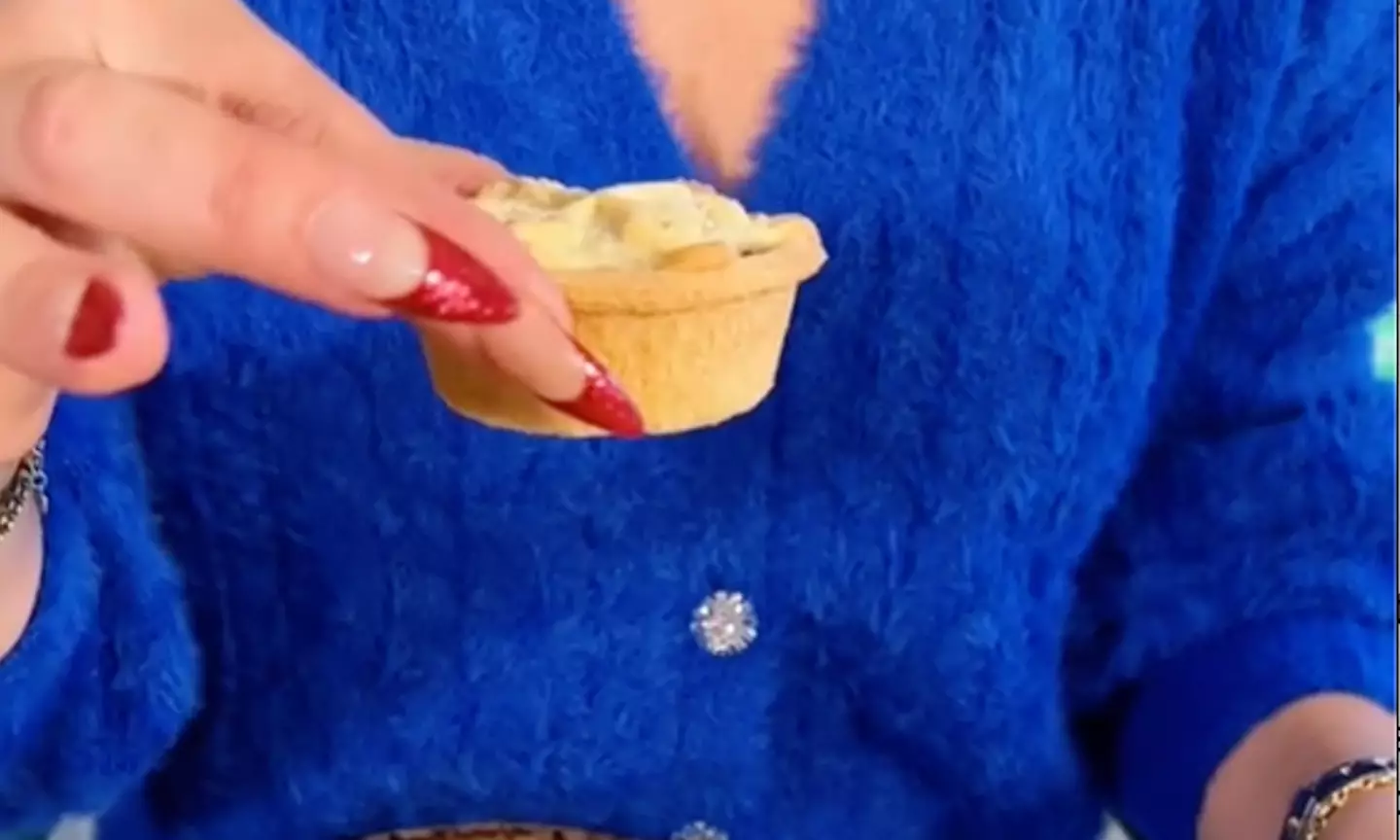 The mince pie should be lifted with your thumb and forefinger.