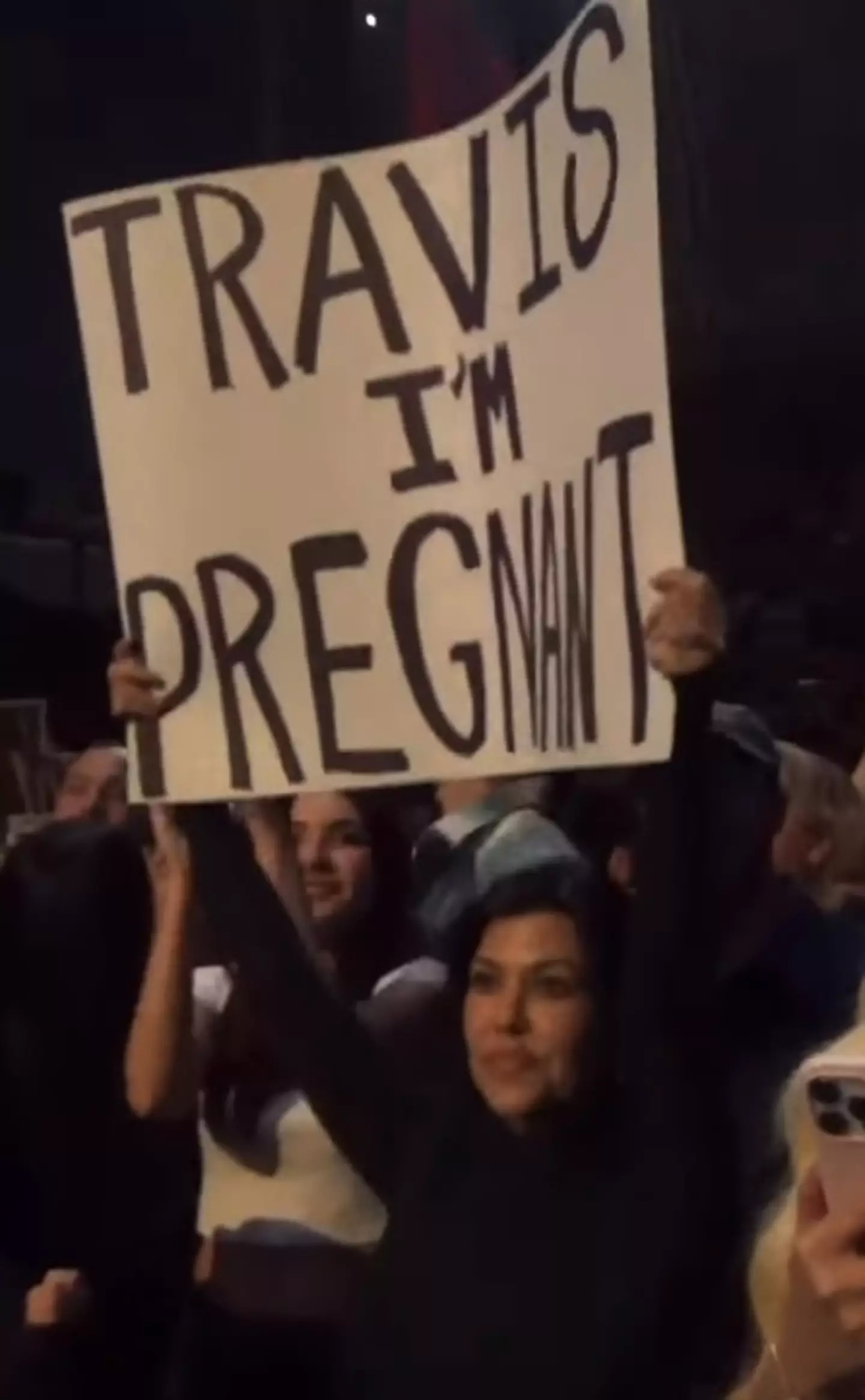 Kourtney Kardashian held up a 'Travis I'm pregnant' sign at the Blink-182 gig.