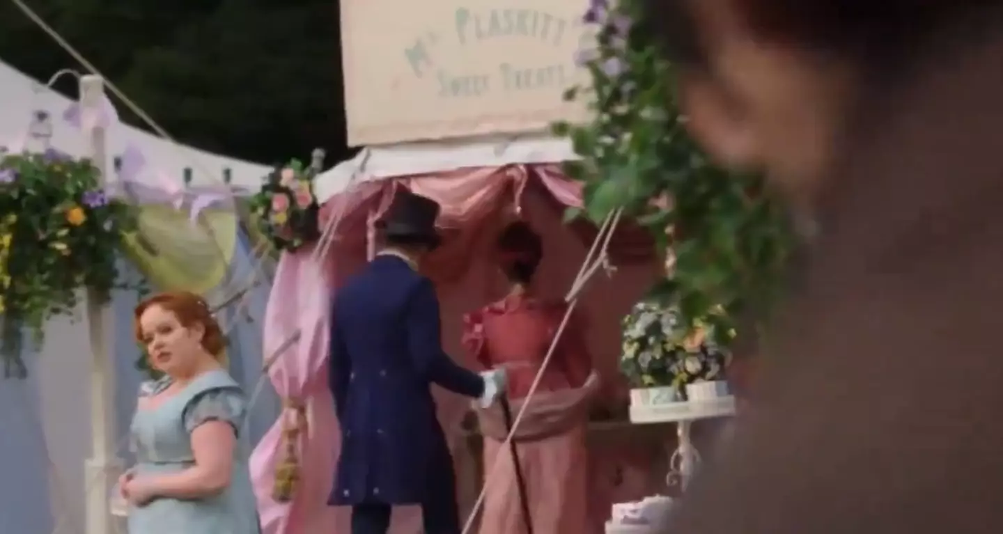 Penelope beckons Colin over with a subtle head nod. (Netflix)