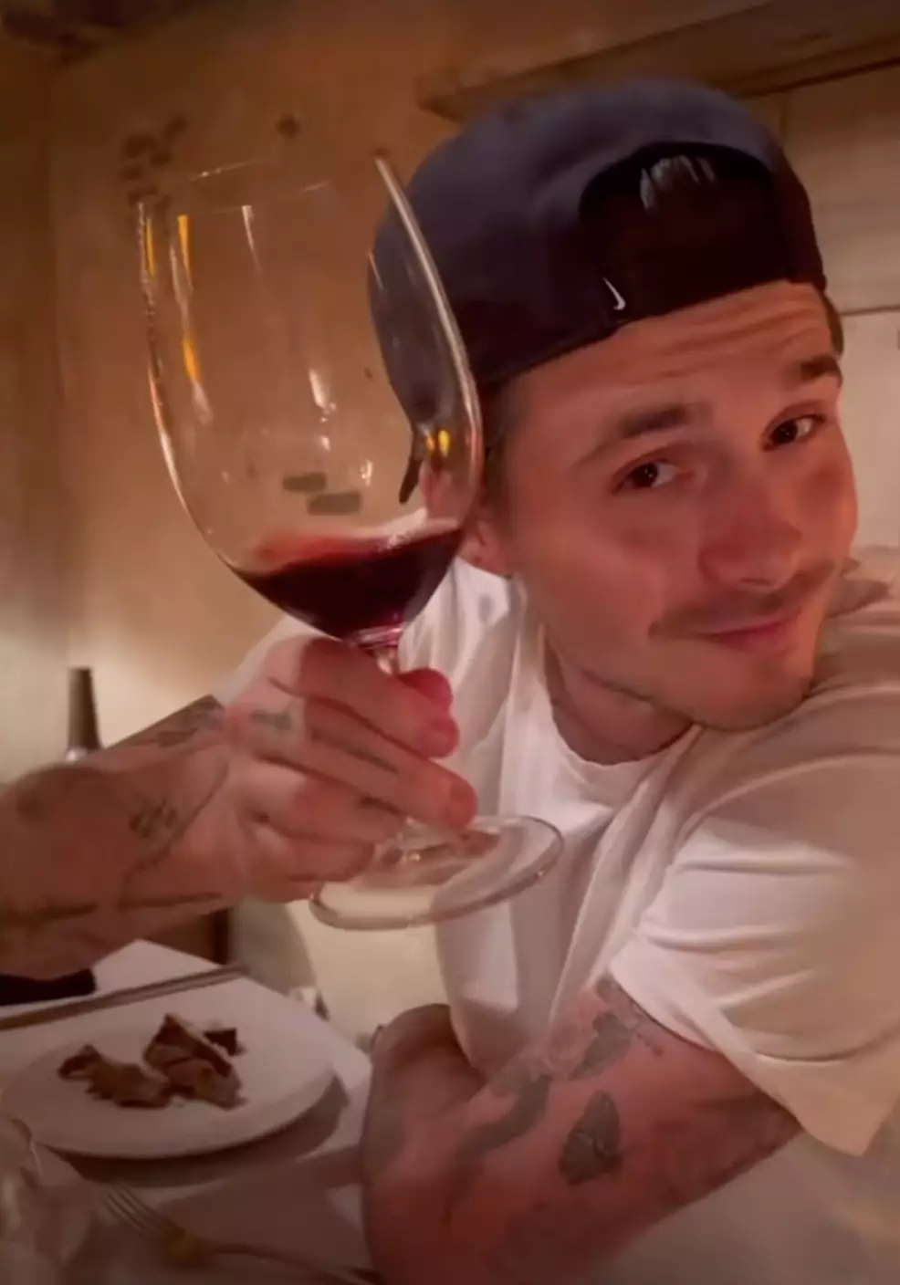 Brooklyn was seen drinking wine and enjoying food in the clip (Instagram/@nicolaannepeltzbeckham)