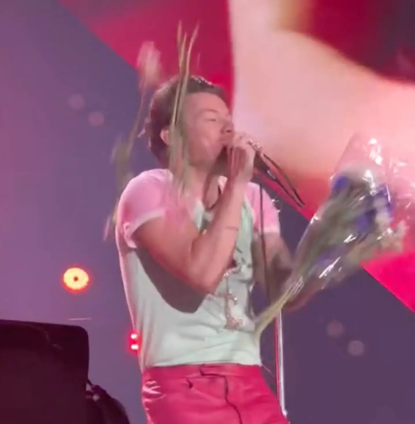 Harry Styles tried to bat away the flowers as they flew towards him.