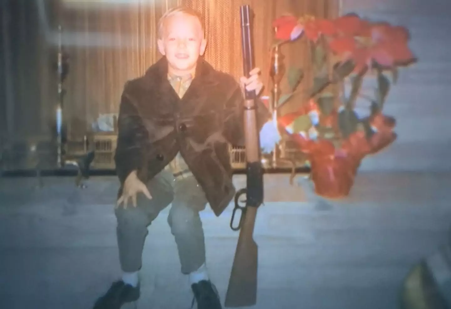 Joe Exotic as a child posing with a rifle (