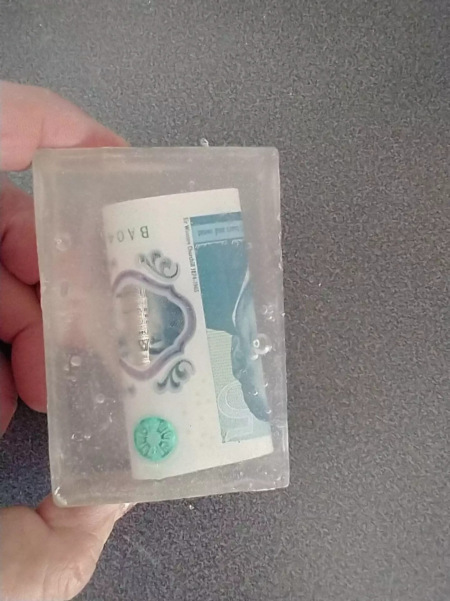 The five pound note is inside the soap (