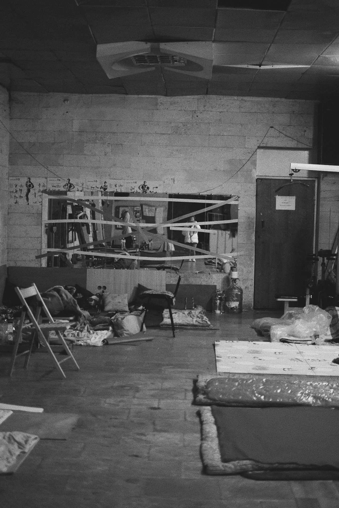 Mirrors are being held together with duct tape, and mattresses are on the floor (