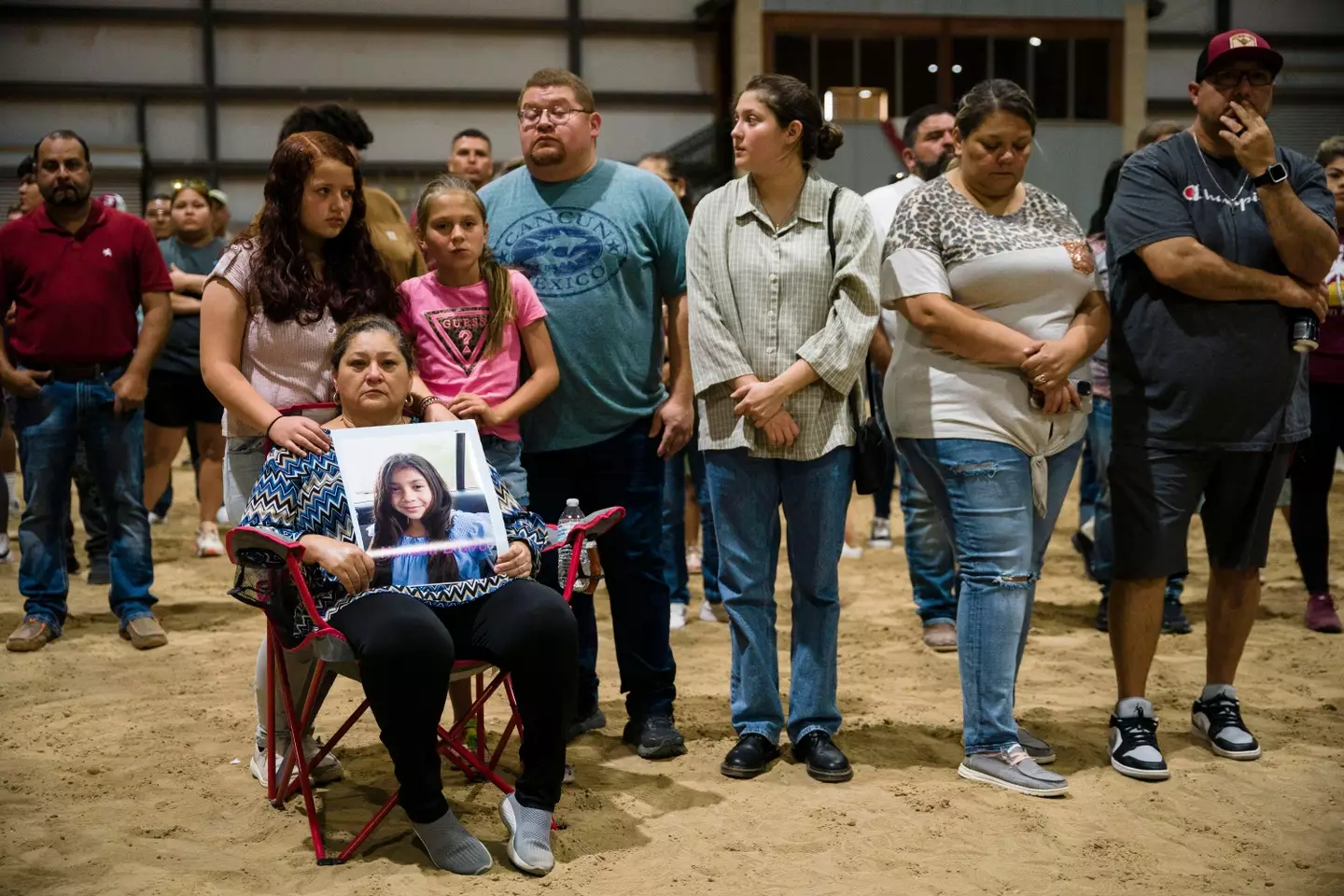 The family of Nevaeh Bravo hold a photo of her at a vigil for the Robb Elementary School shooting victims. (
