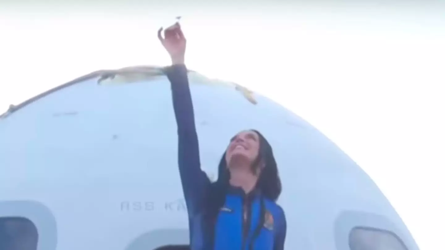 Katy Perry appeared to make a sweet tribute to her daughter, Daisy Dove, upon exiting the Blue Origin spacecraft (YouTube/Blue Origin)