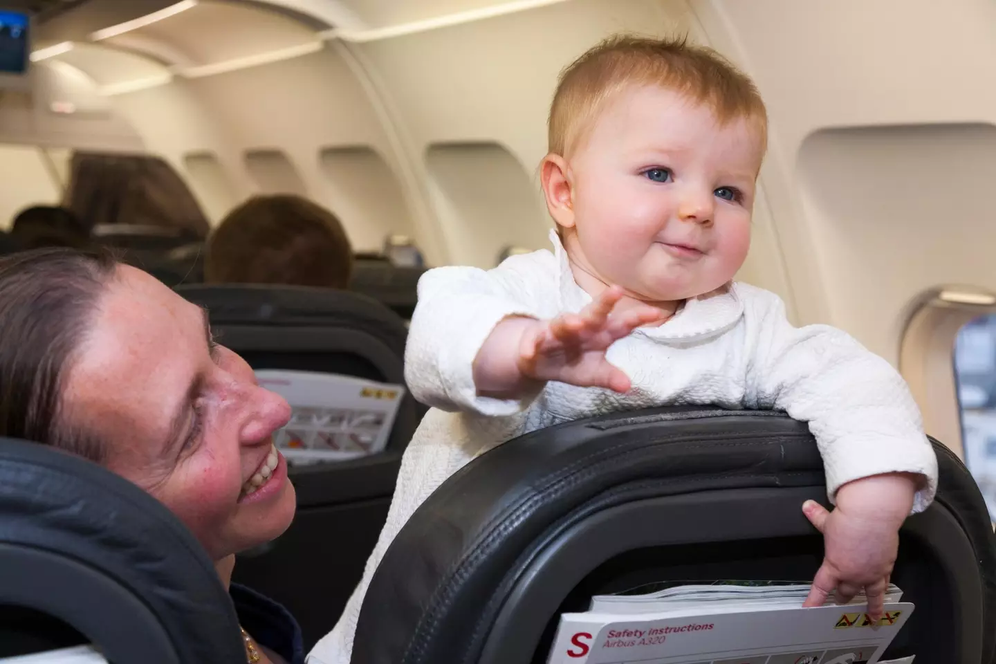 The woman has tickets with her toddler in economy, while her husband has business class tickets through his work.